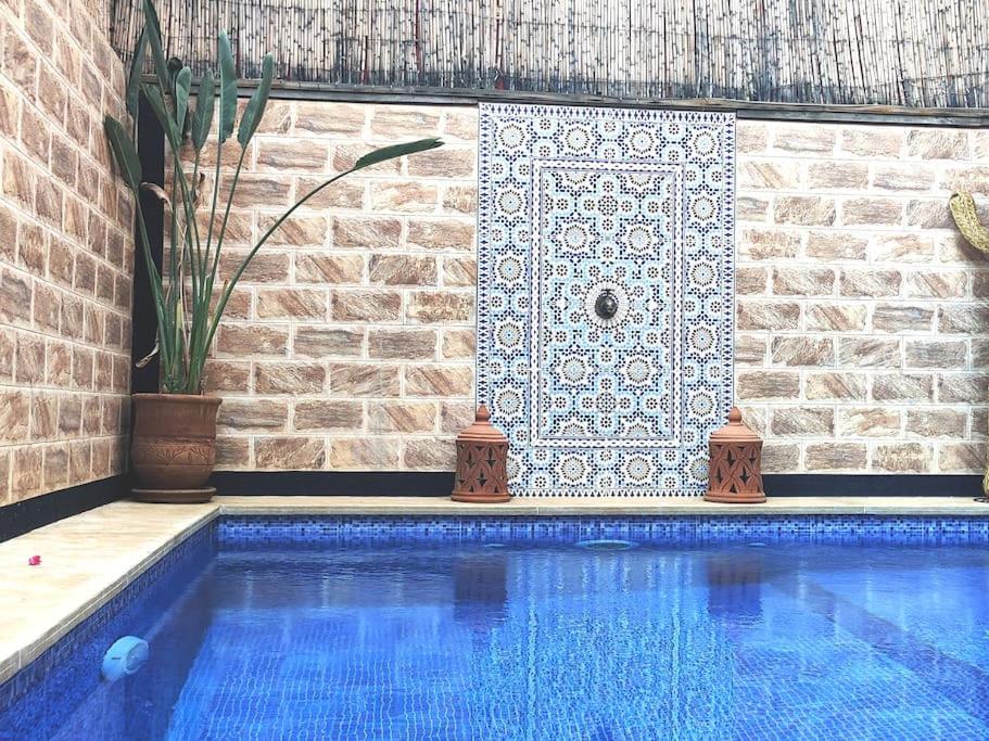 a swimming pool next to a brick wall with a tile at Villa Dar Bella in Aït Ali