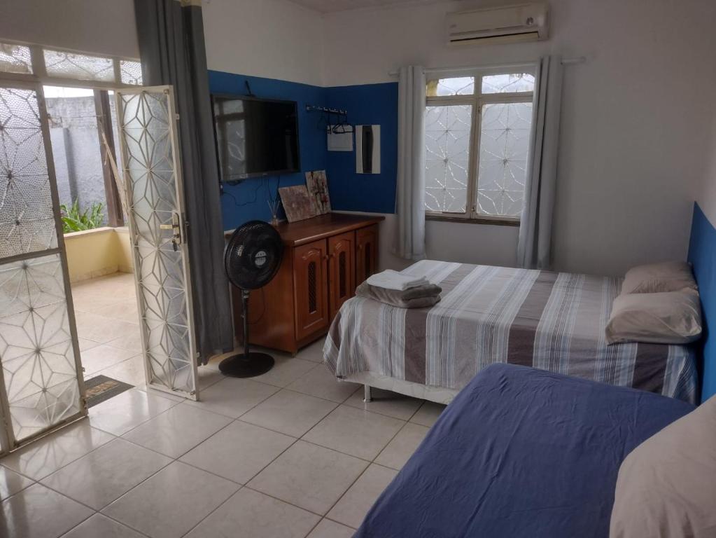 1 dormitorio con 2 camas y TV. en Meu Oca en Boa Vista