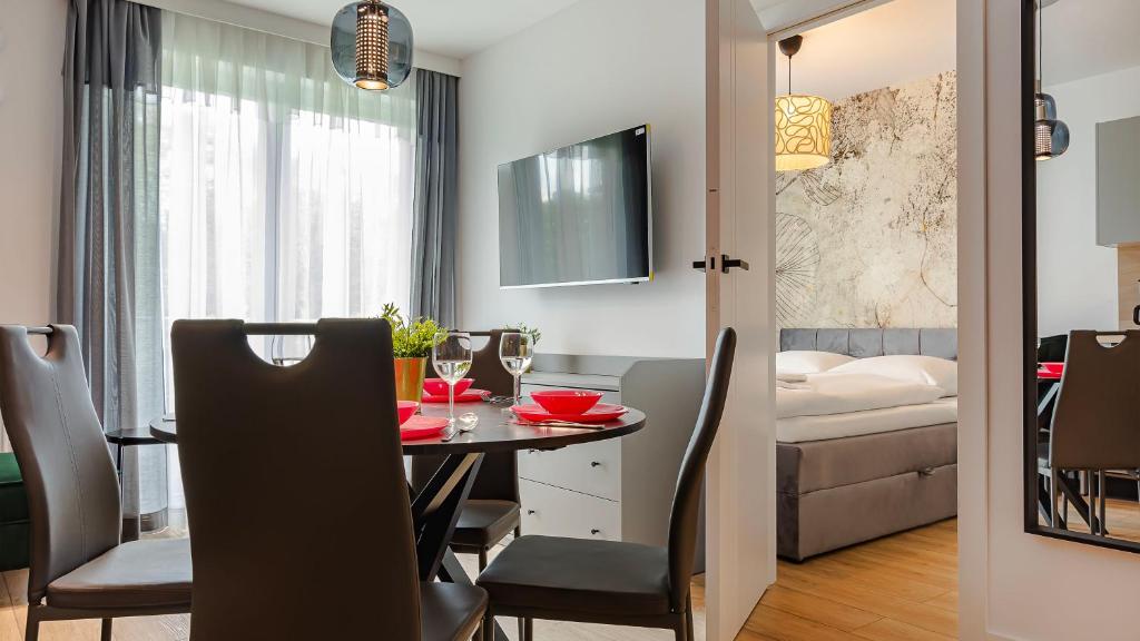 a dining room and living room with a table and chairs at VacationClub - Porta Mare 15 Apartament 10A in Kołobrzeg