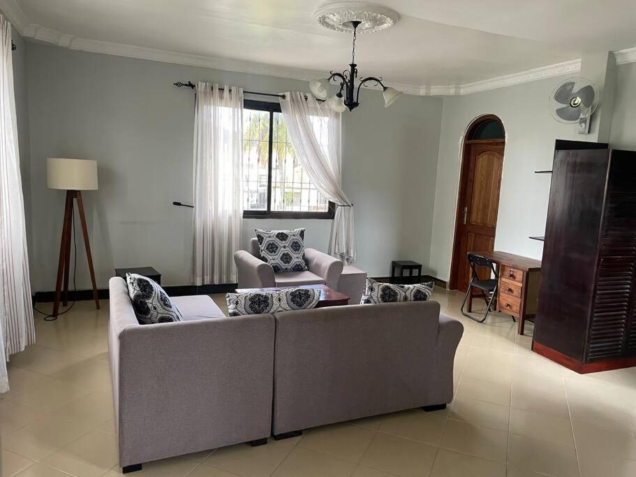 a living room with a couch and a table at Cheerful studio apartment in Dar es Salaam