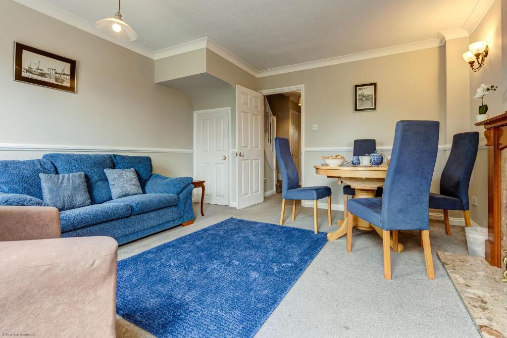 a living room with a blue couch and a table at The Didcot White House in Didcot