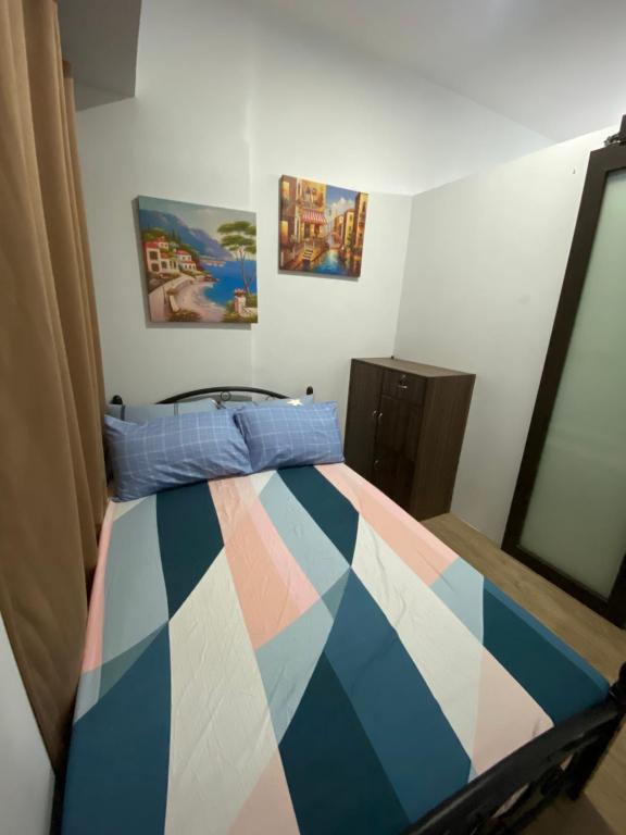馬尼拉的住宿－Anuva Magical Room，一间卧室配有一张带五颜六色棉被的床