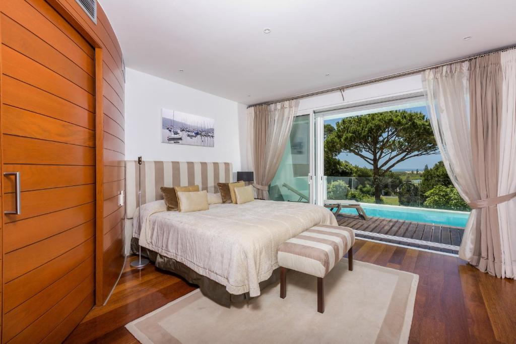 um quarto com uma cama e uma grande janela em Sunny Lounge Apartment em Vale do Lobo