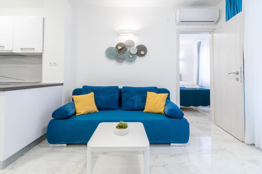 een blauwe bank in een witte woonkamer met een tafel bij Apartment Blue in Makarska