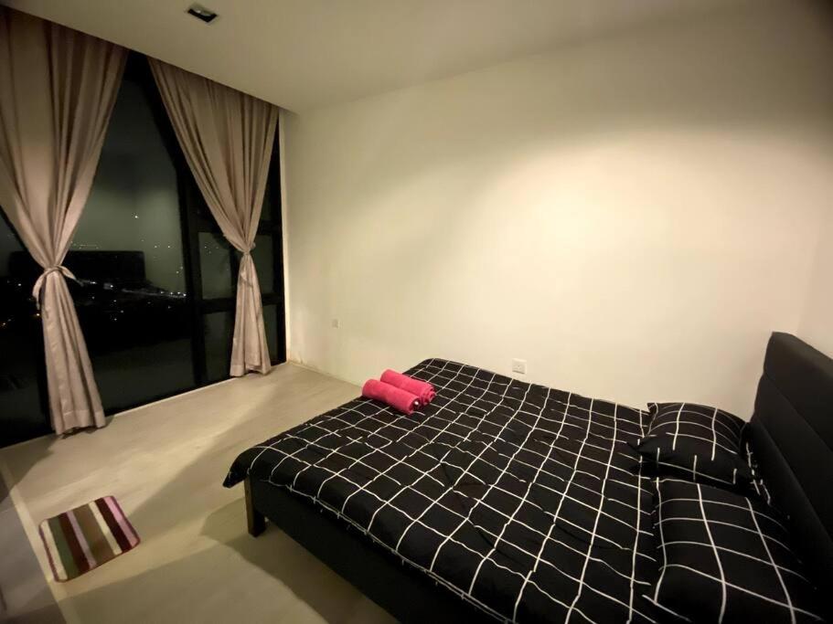 een slaapkamer met een zwart bed met een rood voorwerp erop bij Rehat Guest House, The Square, One City, USJ25 in Subang Jaya