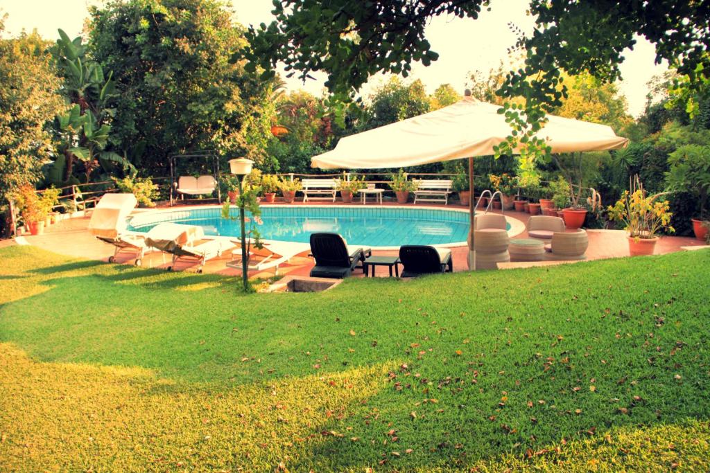 una piscina con tumbonas y sombrilla en Villa San Bartolomeo, en San Gregorio di Catania