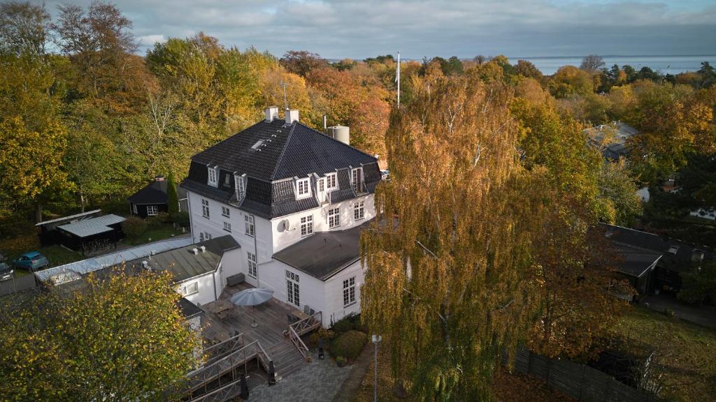 uma vista aérea de uma grande casa branca com um telhado preto em Rørvig Centret em Rørvig