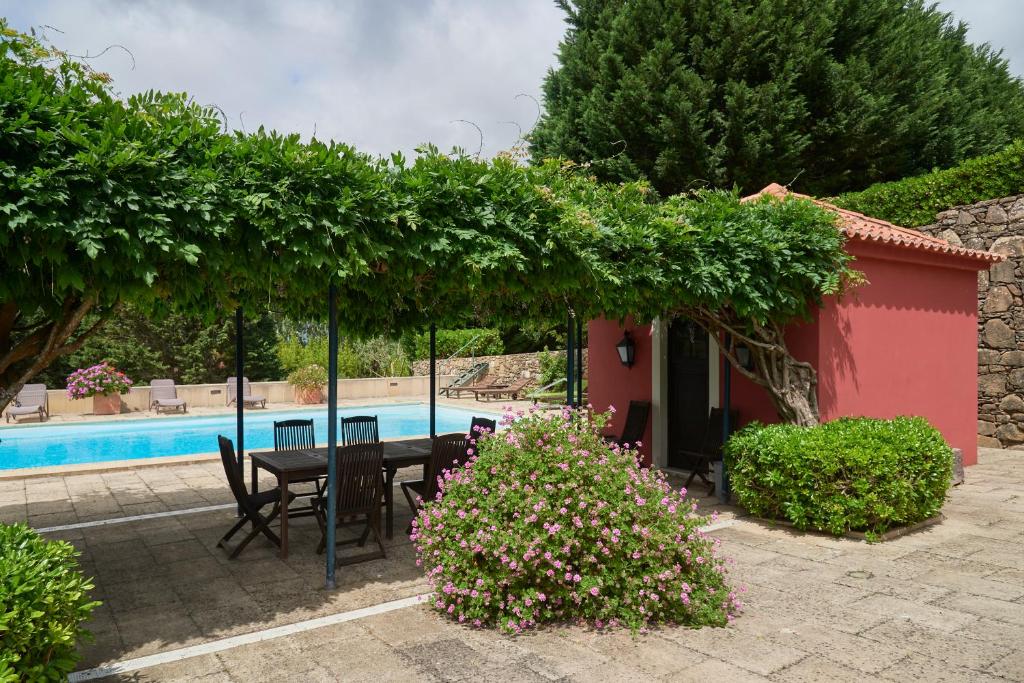 eine Terrasse mit einem Tisch und Stühlen neben einem Pool in der Unterkunft Deluxe Bedroom in Farmhouse, Swimming Pool, By TimeCooler in Sobral de Monte Agraço