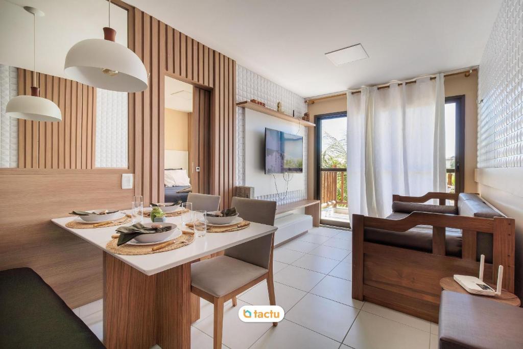 a kitchen and living room with a table and chairs at Estúdio completo no VG Sun Cumbuco por Tactu in Paracumbuca