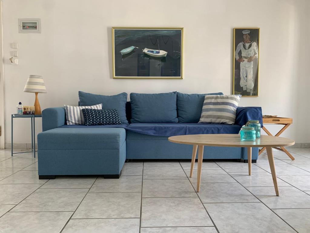 a blue couch in a living room with a table at Blue Maison in Paralia Katerinis