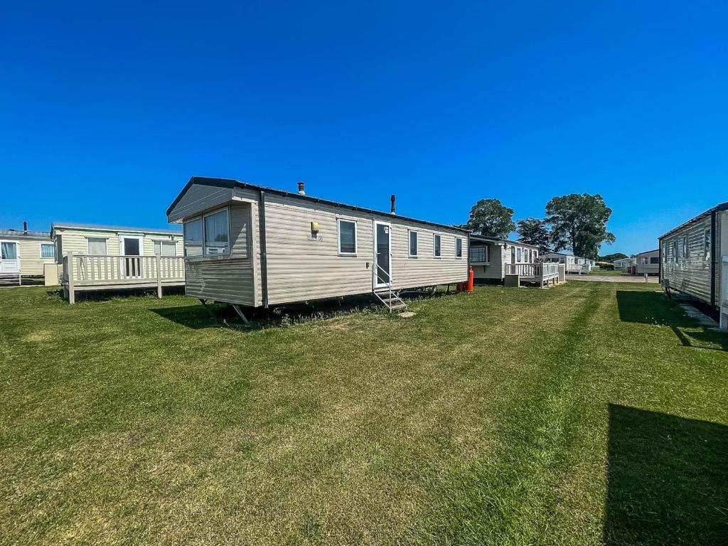 a row of mobile homes in a field of grass at Lovely 6 Berth Caravan At Valley Farm Park In Essex Ref 46762v in Great Clacton
