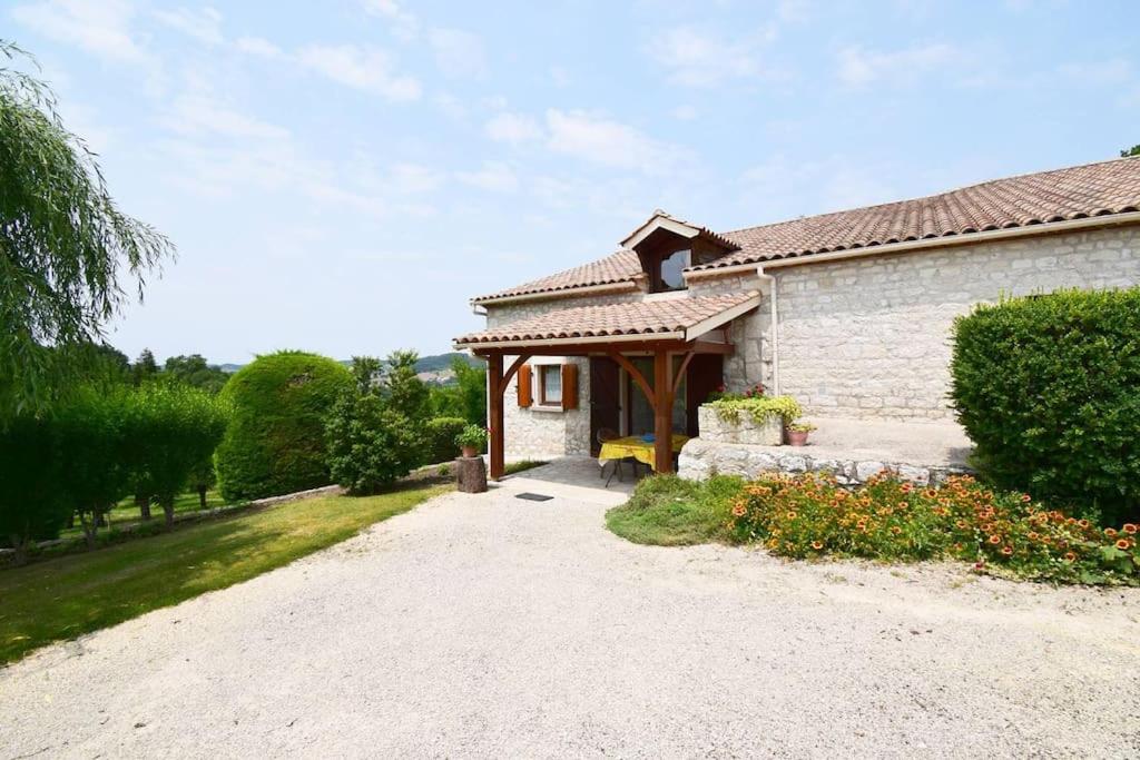 een huis met een veranda en een grindoprit bij Pouchalou - Clévacances 2 Clés in Tournon-dʼAgenais