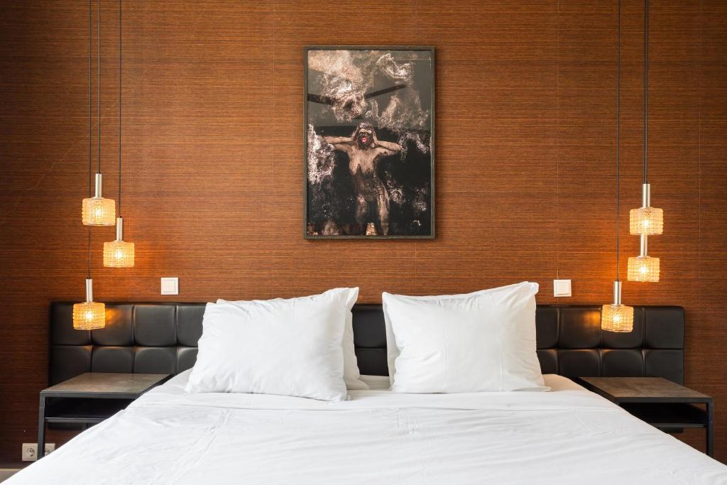 1 dormitorio con 1 cama grande con almohadas blancas en Weber Hotel 397, en Ámsterdam