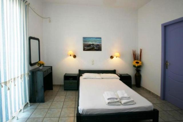 een slaapkamer met een bed met twee handdoeken erop bij Soula Rooms Tinos in Tinos Town