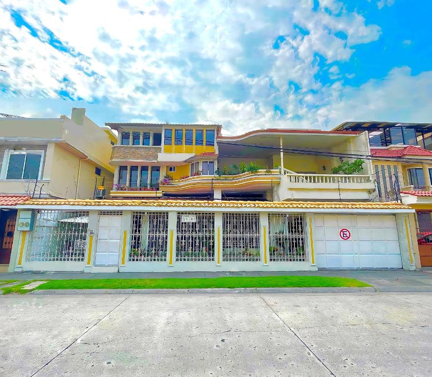 a building with a white fence in front of it at Villa Garza Inn in Guayaquil