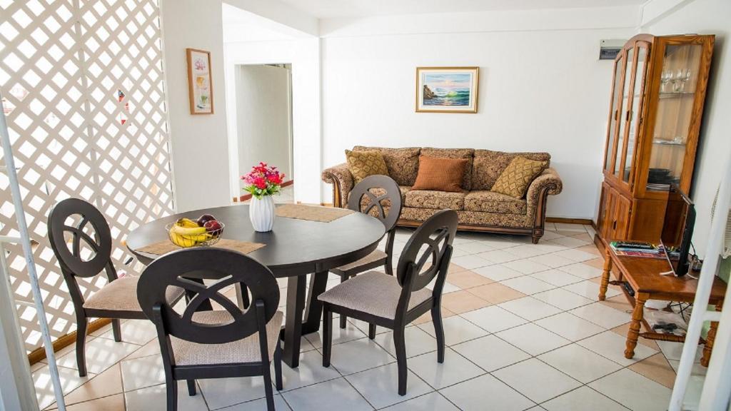 salon ze stołem, krzesłami i kanapą w obiekcie Sephina Villa St Lucia Island Dream Holidays w mieście Cap Estate