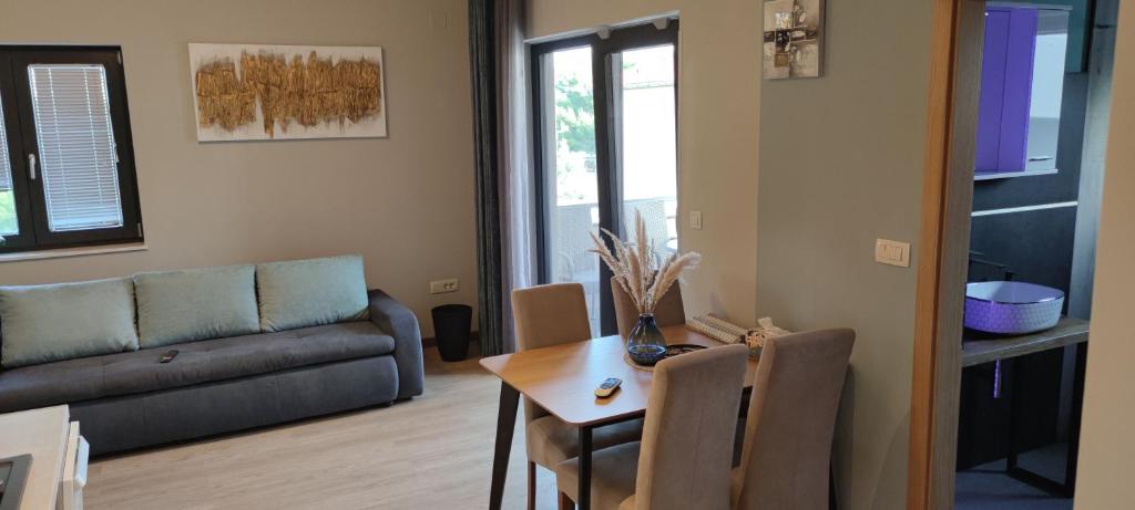 un soggiorno con tavolo e divano di Spacious modern apartment a Biograd na Moru