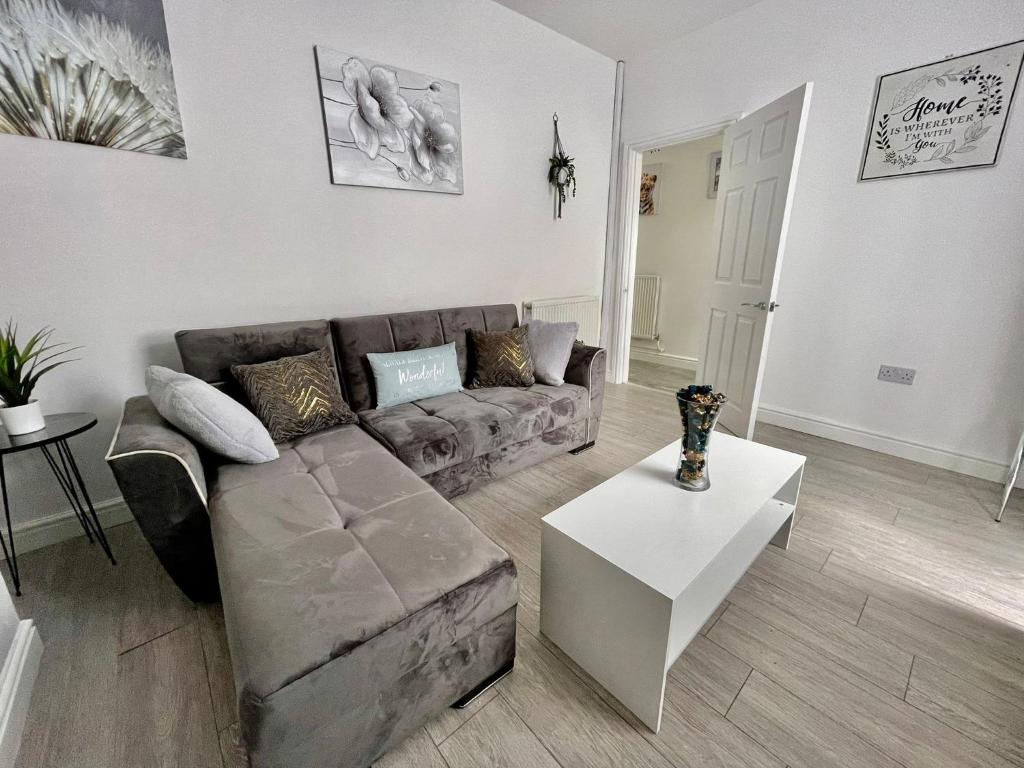 a living room with a couch and a table at Cheerful 3-bedroom Near Bikepark Wales Merthyr Tydfil Town Centre in Merthyr Tydfil