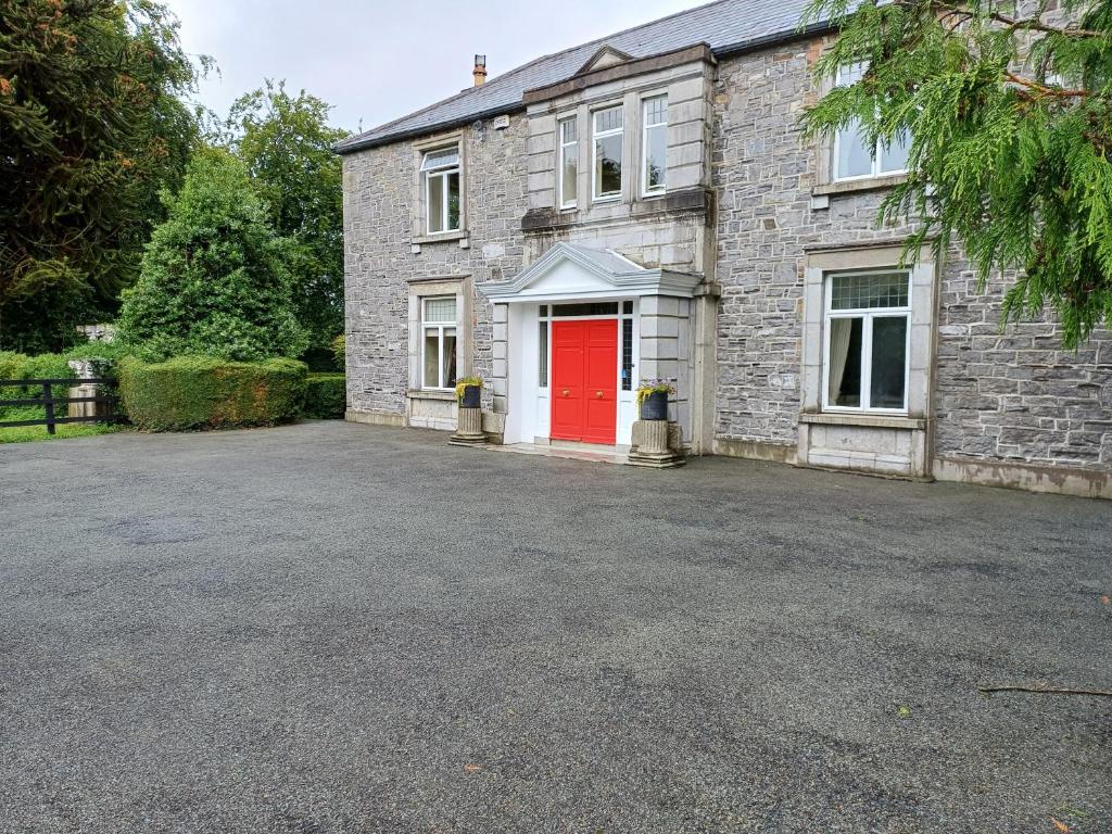 a brick house with a red door and a driveway at Lara, Maynooth W23P9H6 in Maynooth