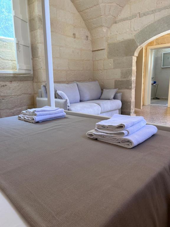 una camera con divano e asciugamani su un tavolo di CORTE COCHLEA a Cannole