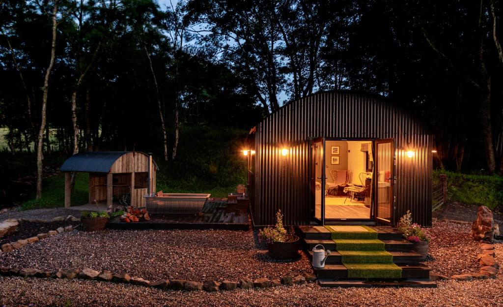 una pequeña cabaña en medio de un patio por la noche en The Hide at Woodside en St Andrews