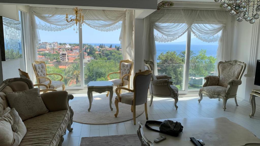 salon z kanapą i krzesłami oraz dużym oknem w obiekcie Antalya’nın kalbinde büyüleyici bir sığınak w mieście Antalya