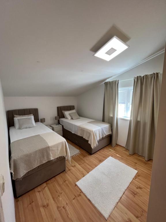 ein Schlafzimmer mit zwei Betten und einem Dachfenster in der Unterkunft Perla Alba Apartments in Tribunj