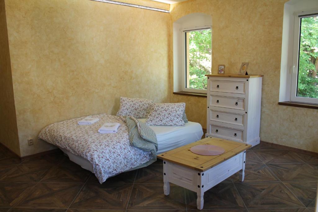 a bedroom with a bed and a dresser and a table at Hrad Vildstejn in Skalná