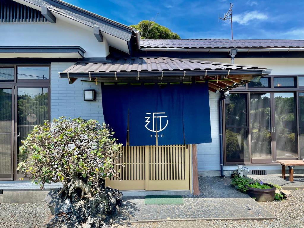 een huis met een blauw gordijn op de deur bij 島の宿 近 別邸〜縁〜 in Oshima