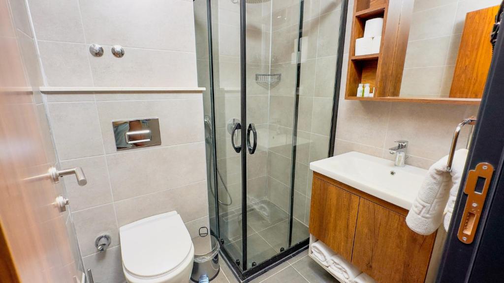 ein Bad mit einer Dusche, einem WC und einem Waschbecken in der Unterkunft Feri Surf Club Hotel Datça in Datca