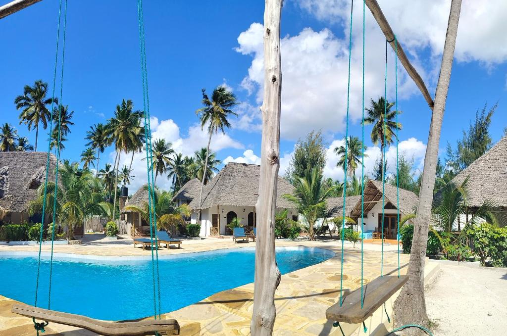 a swing at a resort with a swimming pool at Emerald Dreams Boutique Hotel in Michamvi