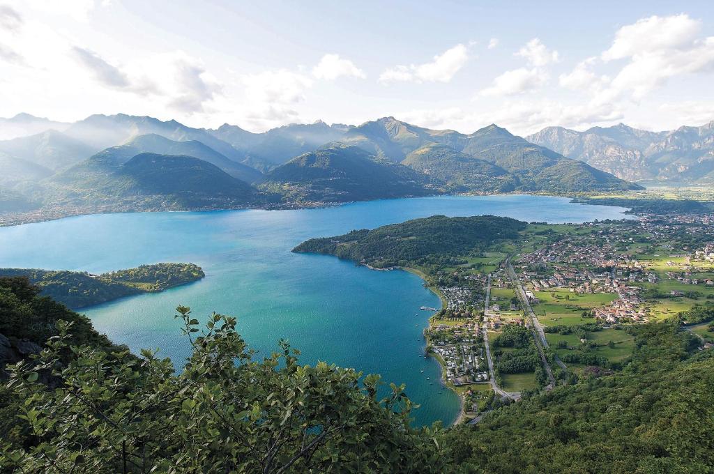 an aerial view of a lake in the mountains at Green Village Accommodations in Colico