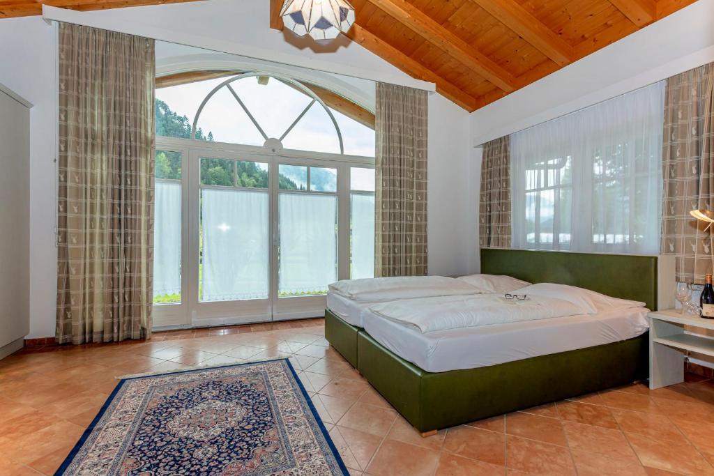 a bedroom with a large bed and a large window at Berghof-Chalet in Erpfendorf