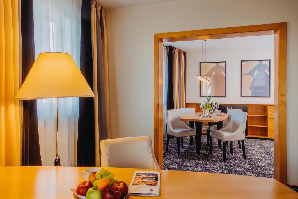 a dining room with a table and chairs and a mirror at Don Giovanni Hotel Prague - Great Hotels of The World in Prague