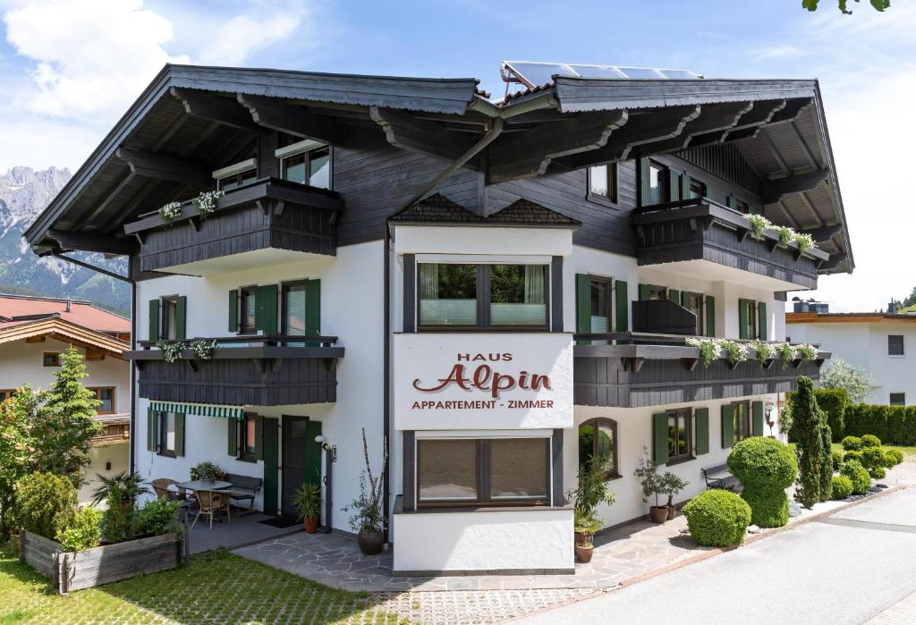 un bâtiment avec un panneau indiquant « HRH Algorithm Apartment Agency » dans l'établissement Haus Alpin, à Ellmau