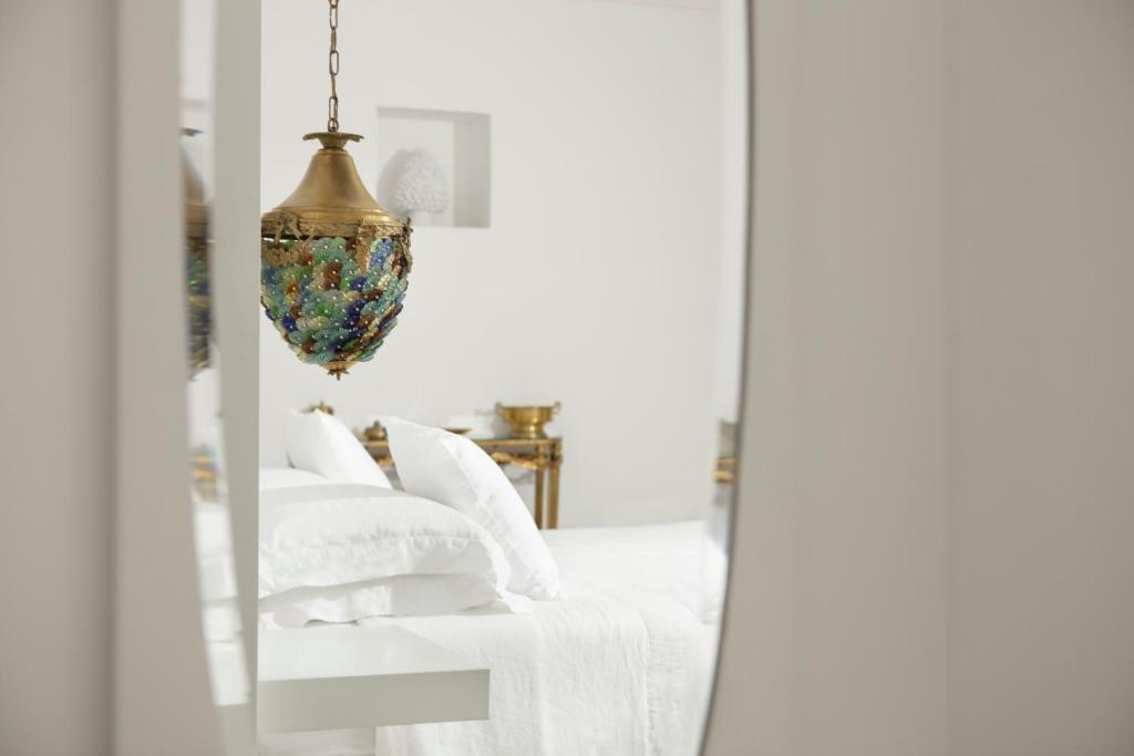 einen Spiegel in einem Schlafzimmer mit einem Bett und einem Kronleuchter in der Unterkunft Relais Carlo Alberto in Salve