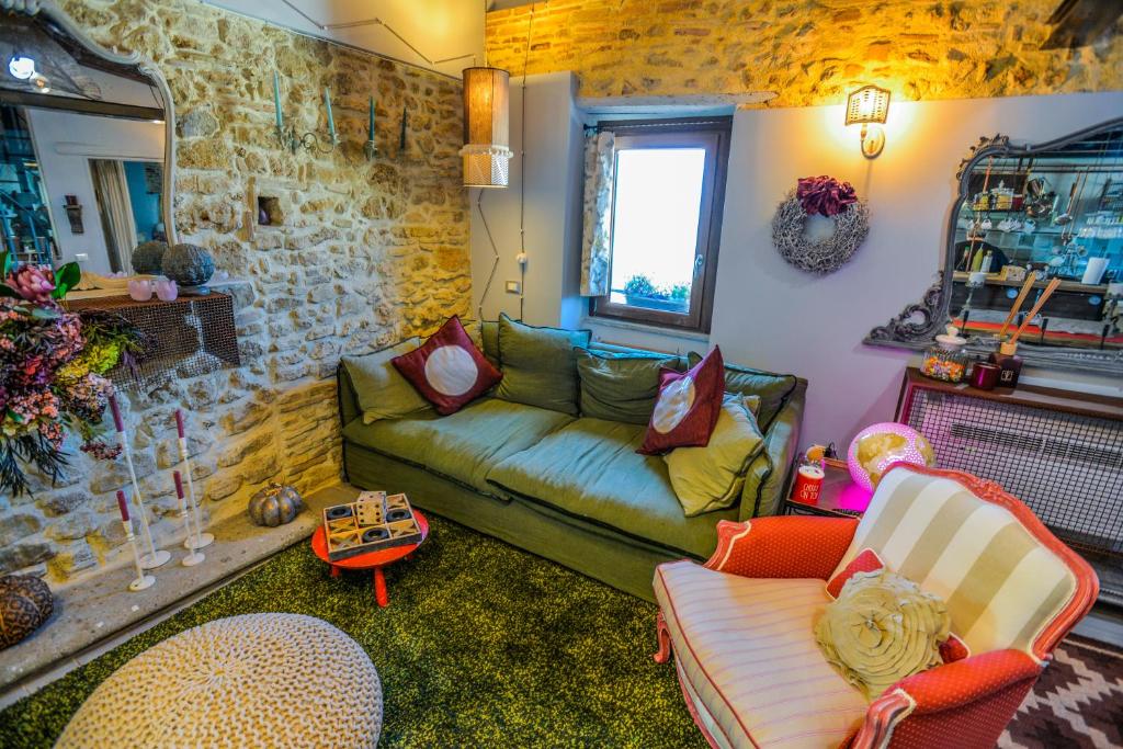 a living room with a green couch and chairs at La Torretta in Torrita Tiberina