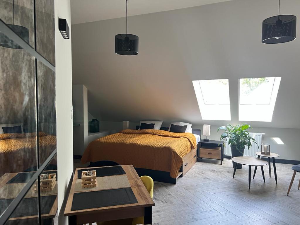 - une chambre avec un lit et une table dans l'établissement Apartamenty Terminal Charzykowy, à Charzykowy