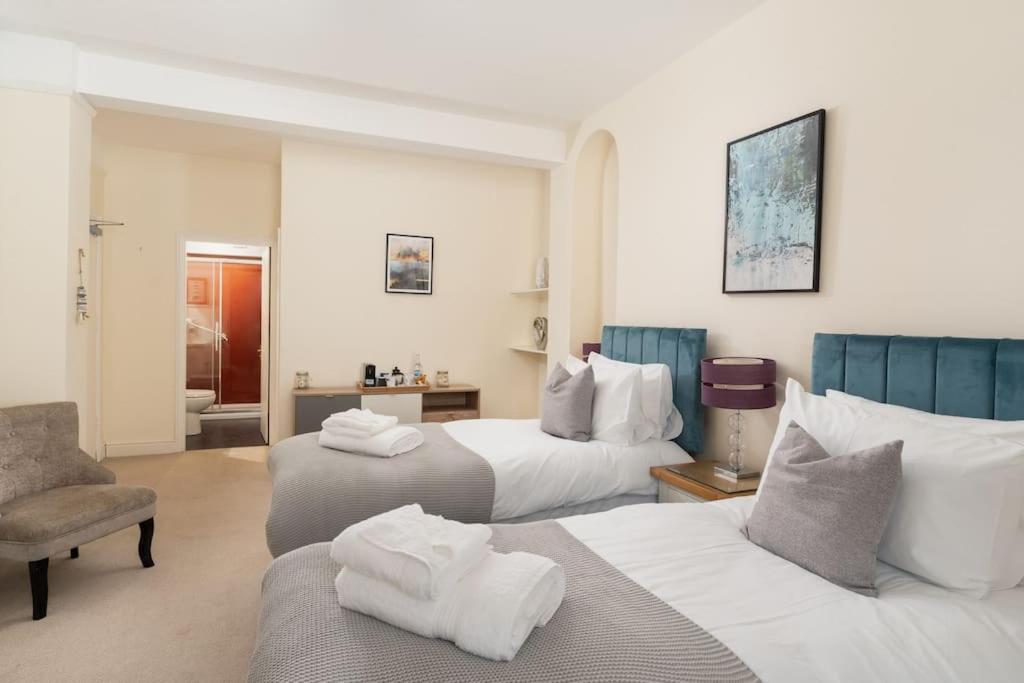 a hotel room with two beds and a chair at Room 1, Hotel style twin bedroom in Marazion in Marazion