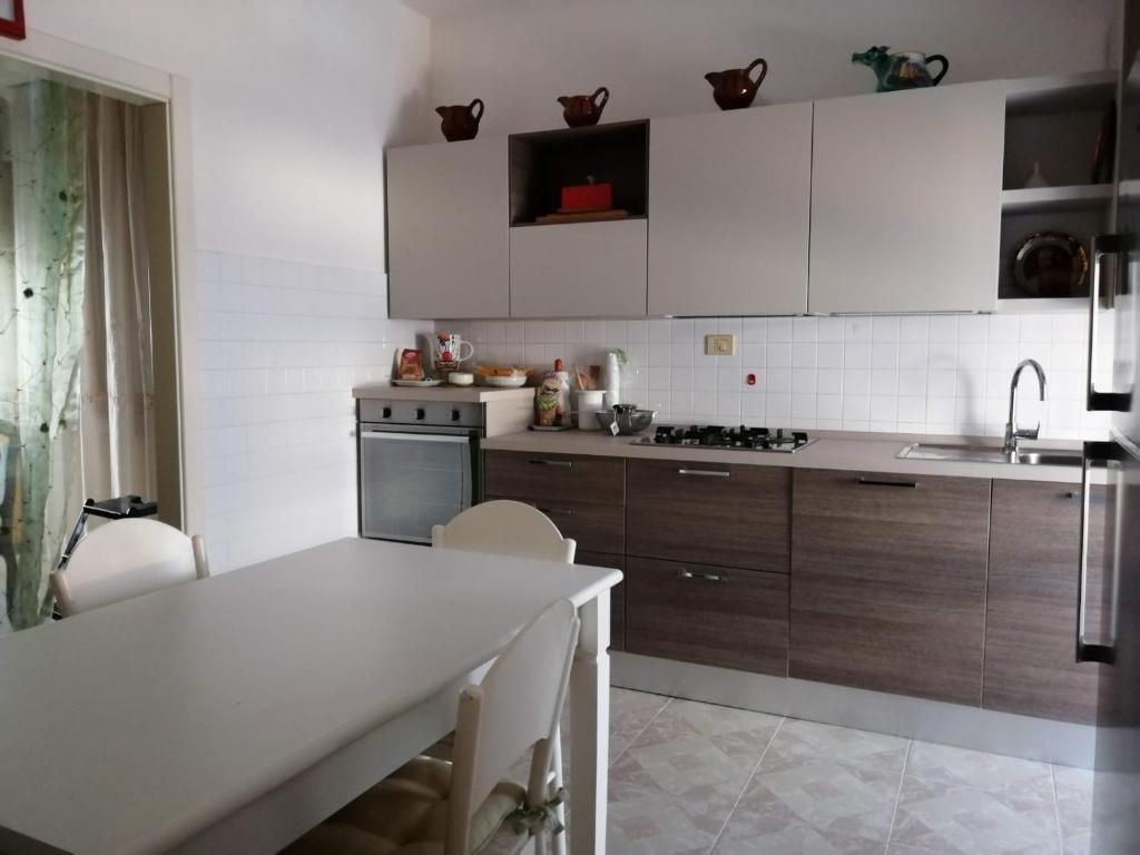 een keuken met houten kasten en een wit aanrecht bij Sirolo - Pesciolino Azzurro in Sirolo