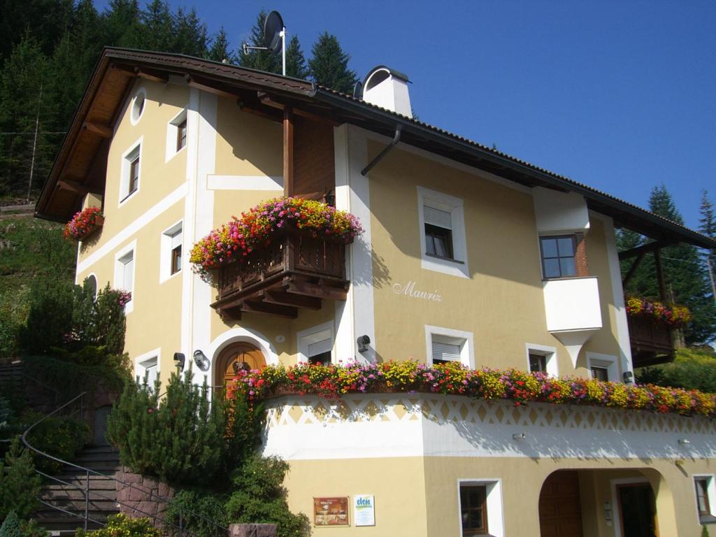 a building with a balcony with flowers on it at Apartments Mauriz in Selva di Val Gardena