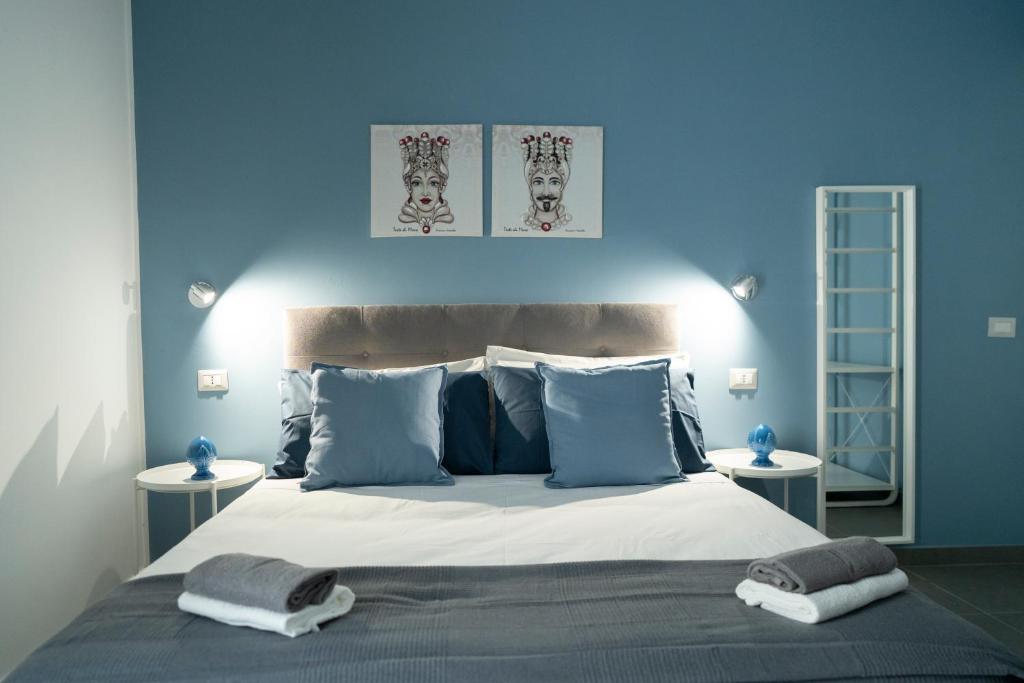a blue bedroom with a large bed with two tables at Al Vicolo Comfort Room in SantʼAgata di Militello