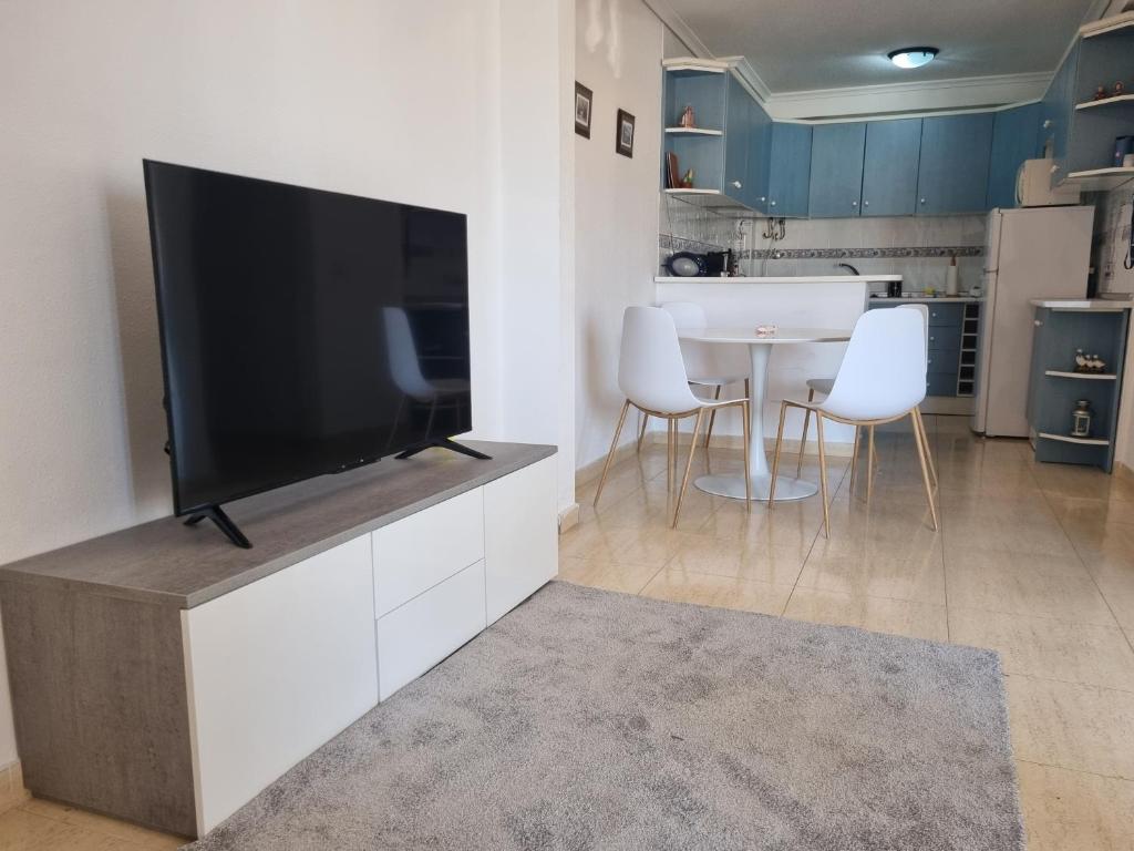 a living room with a large flat screen tv on a cabinet at Monte Mar Apartment in Gran Alacant