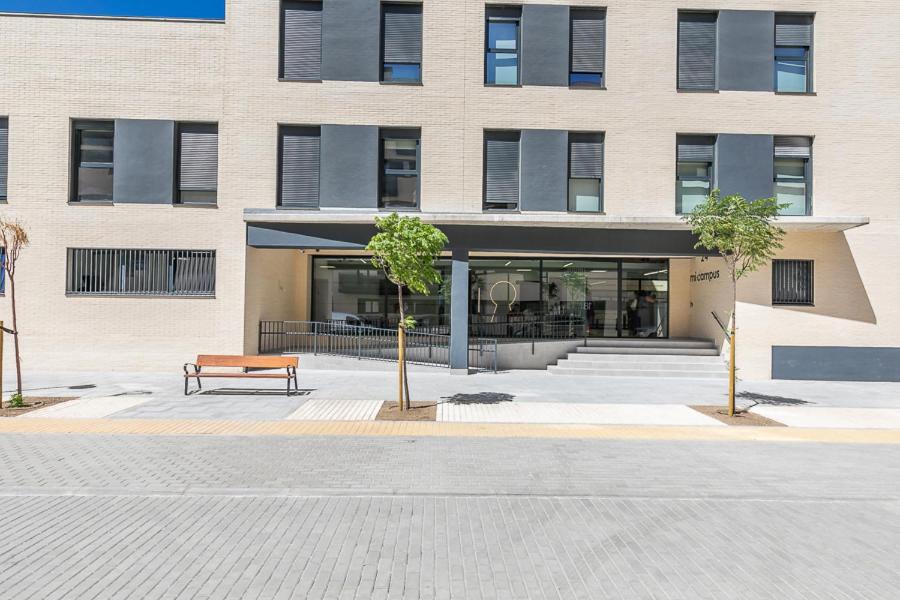 a building with a bench in front of a building at Micampus Getafe in Getafe