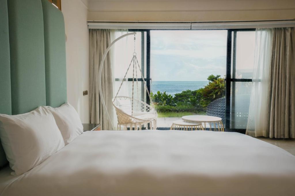 a bedroom with a bed and a view of the ocean at 墾丁曜星海Villa-海景第一排 in Hengchun