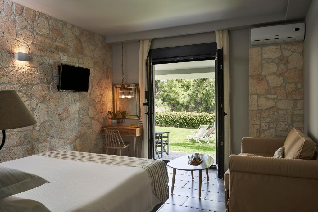sypialnia z łóżkiem i kanapą oraz patio w obiekcie Mirabilia Boutique Hotel w mieście Kriopigi