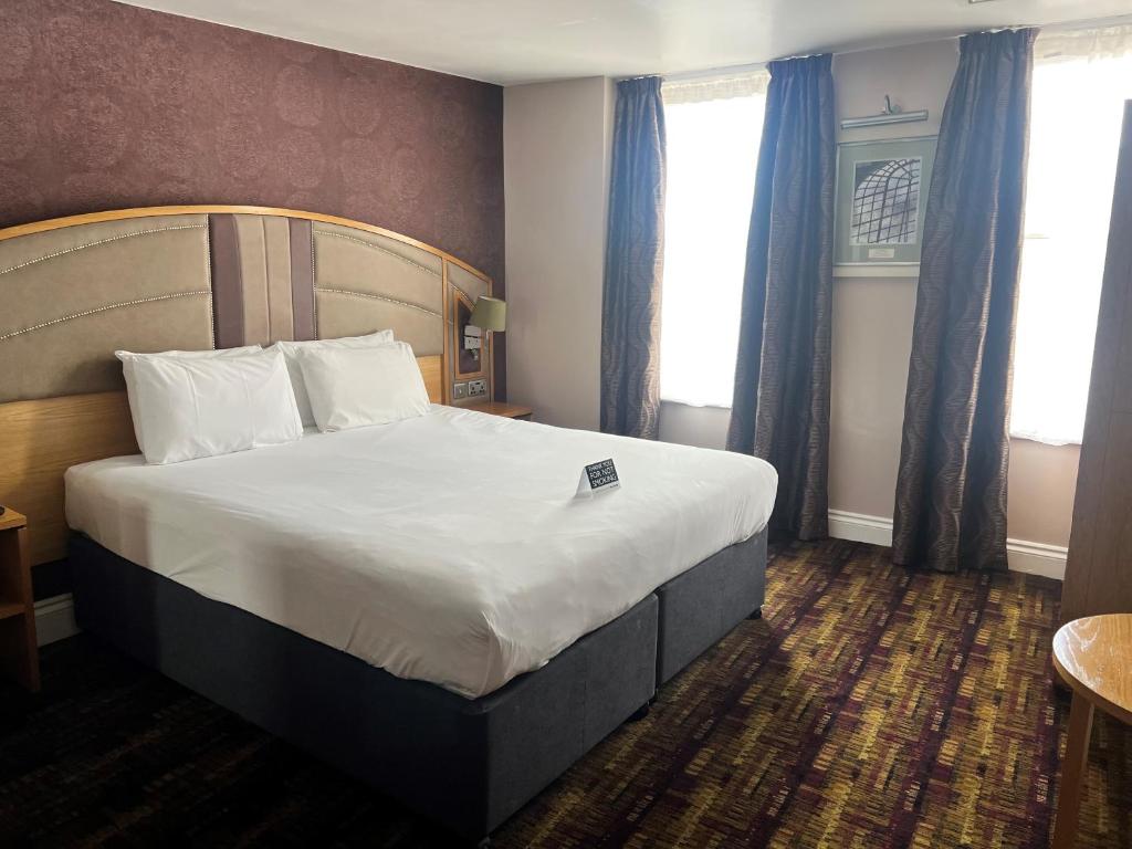 ローチェスターにあるThe Golden Lion Wetherspoonのホテルルーム内のベッドルーム1室(大型ベッド1台付)