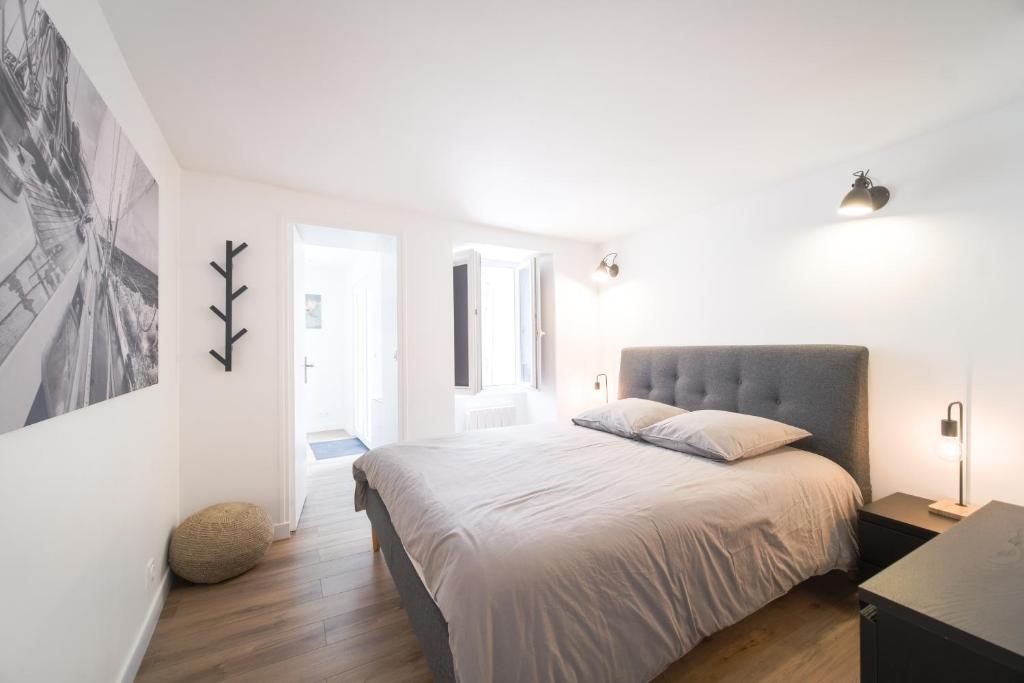 een witte slaapkamer met een groot bed. bij Appart' Terrasse plein centre in La Ferté-Gaucher