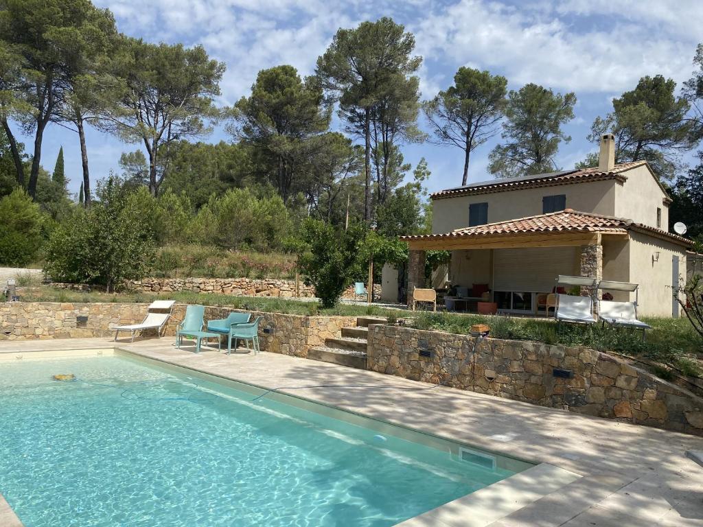 a villa with a swimming pool in front of a house at Mas provençal in Draguignan