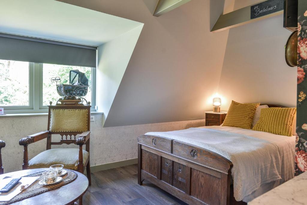 ein Schlafzimmer mit einem Bett, einem Tisch und einem Stuhl in der Unterkunft Hotel Frederiksoord in Frederiksoord